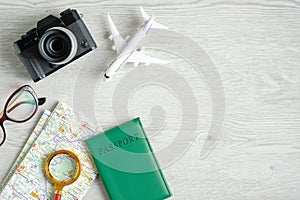 Travel planning concept. Top view traveler accessories, retro style camera, map with magnifying glass, passport, glasses, airplane
