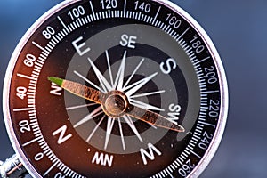 Travel planning navigation concept. Classic black magnetic detail of compass on light blue backround.