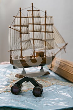 Travel planning - old map, binoculars and boat model
