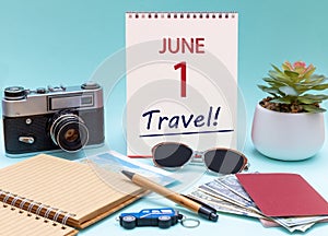 Travel planning, vacation trip - Calendar with the date 1 June glasses notepad pen camera cash passports.