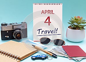Travel planning, vacation trip - Calendar with the date 4 April glasses notepad pen camera cash passports.