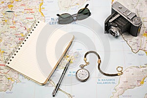 Travel plans with map of island Greece and objects. Camera,sun glasses pocket watch and notebook