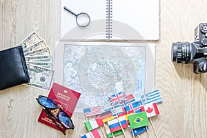 Travel preparation : money, passport, road map ,sunglasses,magnifying glass ,retro film camera ,notebook on wooden table