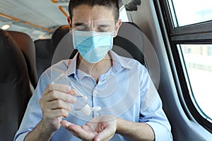 Travel safely on public transport. Business man with surgical mask using wash hand sanitizer gel dispenser. Passenger with