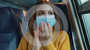 Travel safely on public transport. Young woman with surgical mask using hand sanitizer gel from dispenser.