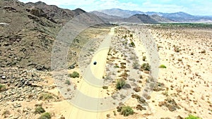 Travel, sand and mountains with truck in dirt road of countryside for freedom, transportation or journey. Adventure