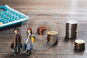 Travel saving and planing concept. couple people traveler miniature figure and stack of coins and calculator background.