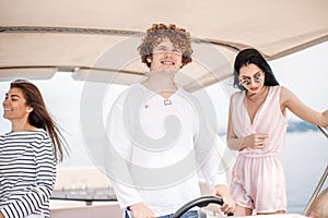 Travel, seatrip, friendship and people concept - friends sitting on yacht deck