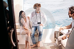 Travel, seatrip, friendship and people concept - friends sitting on yacht deck