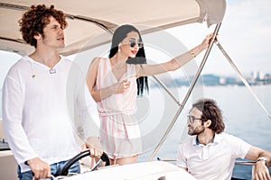 Travel, seatrip, friendship and people concept - friends sitting on yacht deck