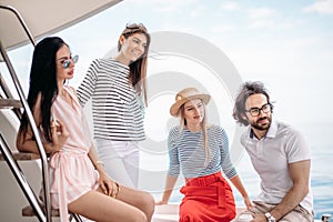 Travel, seatrip, friendship and people concept - friends sitting on yacht deck