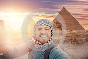 Travel Selfie photo man in hat background pyramid of Egyptian Giza and Sphinx, sunset Cairo, Egyp