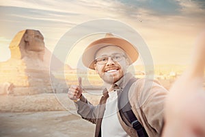 Travel Selfie photo man in hat background pyramid of Egyptian Giza and Sphinx, sunset Cairo, Egyp