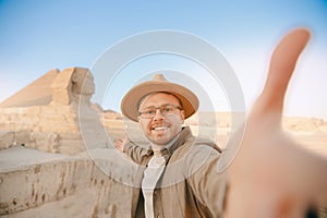 Travel Selfie photo man in hat background pyramid of Egyptian Giza and Sphinx, sunset Cairo, Egyp