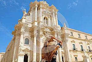 Travel in Sicily. Back view of beautiful girl visiting Syracuse Cathedral on sunny day. Summer holidays in Italy
