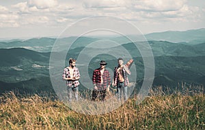 Travel sport lifestyle concept. Three young friends on a country walk. Group of friends on a mountain. Camping Hiking