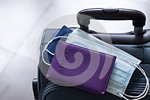Travel suitcase, passport and mask. The ban on travel during the epidemic of the coronavirus and the introduction of quarantine photo
