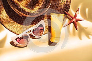Travel summer accessories and sunscreen with shadow of tropical leaves on color background with copy space, Vacation planning