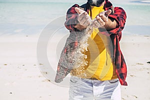 Travel and summer holiday vacation with man holding sand on hands falling down - earth`s day concept with people enjoying the