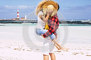 Travel and summer people holiday vacation couple hidden by straw hat kissing and enjoying romantic love relationship together at