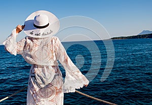 Travel summer woman on holiday in white hat and view of ocean