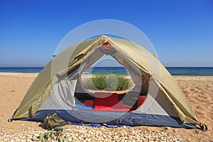 Travel tent on wild sandy seashore