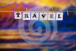 Travel text on papers with clothespins with garland bokeh on background