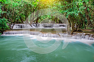 Travel to the beautiful waterfall in tropical rain forest, soft water of the stream in the natural park at Kanchanaburi, Thailand