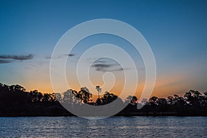 Travel to a portion of river with a natural scenery of sunset over a dock with lights photo