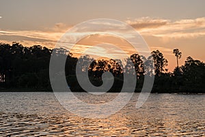 Travel to a portion of river with a natural scenery of sunset over a dock with lights photo