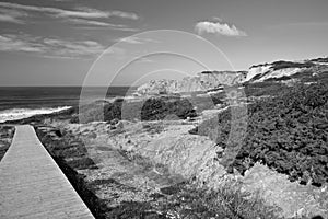 Travel to scenic seascape empty wooden pathway leading to atlantic ocean with waves