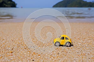 Travel to the sea, small yellow car on the beach. Vacation and tourism concept.postcard with small car rides on sandy