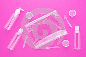 Travel toiletries, small plastic bottles for hygiene products on pink background