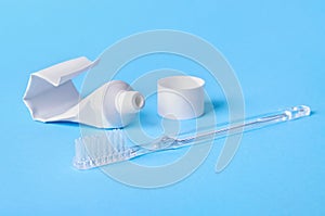 Travel toothbrush and toothpaste on blue background selective focus