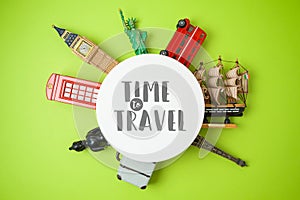 Travel and tourism concept with souvenirs from around the world on green  background