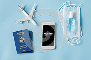 Travel and Tourism Planning after Quarantine. Smartphone with airplane model, passports, face mask and sanitizer
