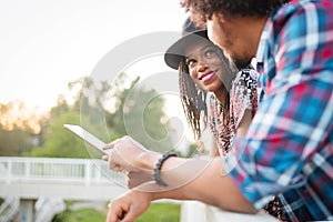 Travel, tourism, summer vacation, technology and friendship concept - smiling couple with tablet pc