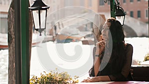 Travel tourist woman in cafe against beautiful view on venetian chanal in Venice, Italy.