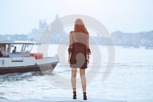 Travel tourist woman on pier against beautiful view on venetian chanal in Venice, Italy.