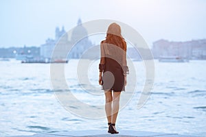 Travel tourist woman on pier against beautiful view on venetian chanal in Venice, Italy.