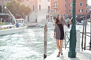 Travel tourist woman on pier against beautiful view on venetian chanal in Venice, Italy.