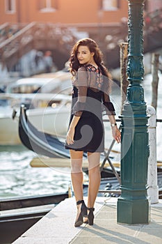 Travel tourist woman on pier against beautiful view on venetian chanal in Venice, Italy.