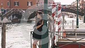 Travel tourist woman on pier against beautiful view on venetian chanal in Venice, Italy.