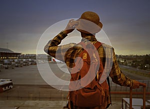 Travel tourist of young man  in hat standing with luggage watching sunset