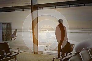 Travel tourist of young man  in hat standing with luggage watching sunset at  Lounge