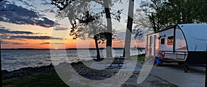 Travel trailer camping at sunset by the Mississippi river in Illinois at sunset panorama