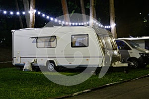 Travel Trailer Caravaning. RV Park Camping at Night. European mobile home on a camping site at night