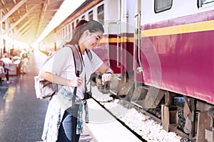 Travel transport concept. traveler girl look at watches in the train station. Young woman check time waiting for train