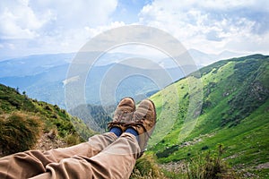 Travel, trekking. Foot traveler in shoes, against the backdrop of mountains. Horizontal frame
