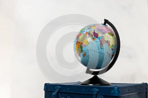 Travel or turism concept. Isolated globe on blue suitcase